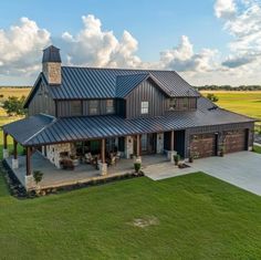 a large house with a metal roof in the middle of a field