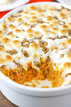 a casserole dish with marshmallows in it on a wooden table