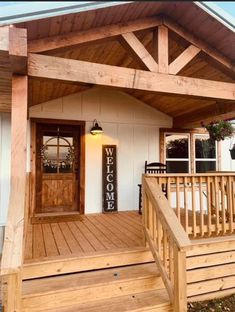 a wooden porch with steps leading up to the front door and side entrance that has a welcome sign on it