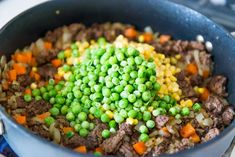 peas, carrots and other vegetables are mixed together in a skillet on the stove