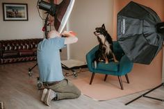 a man sitting on a chair with a dog in front of him