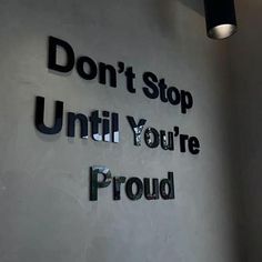 a sign that says don't stop until you're proud on the wall