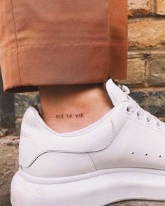 a woman's foot with a small tattoo on her left ankle and the words, we are at me