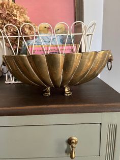 a metal bowl sitting on top of a dresser