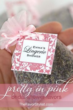 a person holding a small jar filled with pink flowers and lavenders for bridal shower favors