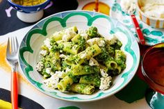 a bowl filled with broccoli and fettuccine on top of a table