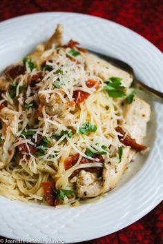 a white plate topped with pasta and meat