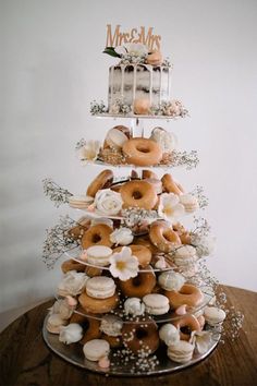 a tiered cake with donuts and flowers on it