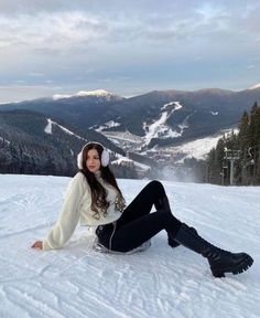 a woman sitting in the snow wearing headphones