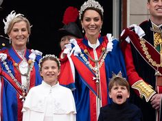 a group of people standing next to each other in front of a window wearing costumes