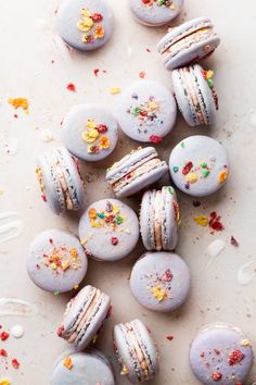 macaroons with sprinkles and confetti on them are scattered around