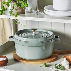 a large pot sitting on top of a wooden cutting board