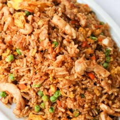 a white plate topped with fried rice and veggies