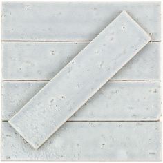 a piece of white tile sitting on top of a wooden floor