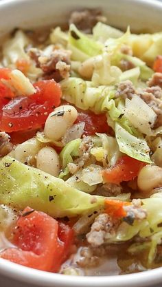 a close up of a bowl of food with broccoli, tomatoes and beans