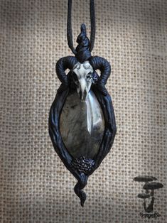 a pendant with a cow head hanging from it's side