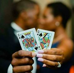 two people holding playing cards in their hands