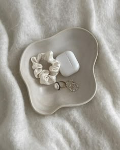 a white plate with some hair accessories on top of it and a cell phone in the middle