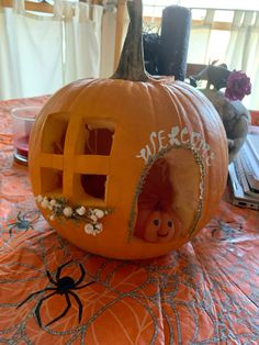 an orange pumpkin with the word house carved into it's face and spider web