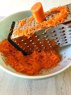 two graters are being used to grate carrots on a white plate