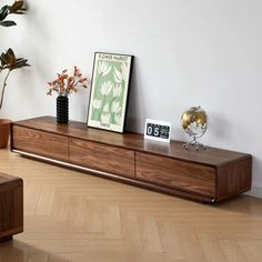 a living room with some plants and pictures on the shelf next to it's coffee table