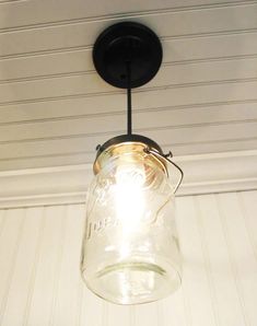 a mason jar hanging from the ceiling with a light bulb on it's side