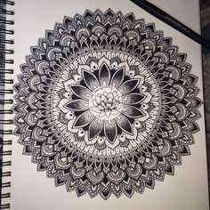 a black and white drawing of a flower in the middle of a spirally design