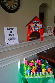 a bunch of toys sitting on top of a table in front of a sign that says adopt a pup