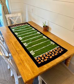 a table with a football field rug on it in the middle of a dining room