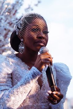 a woman wearing a veil holding a microphone