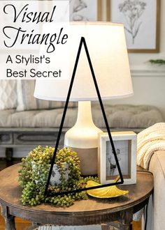 a table with a lamp and pictures on it in front of a couch, which has the words visual triangle