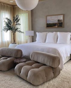 a large bed sitting in the middle of a bedroom next to a window with curtains