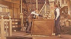 two men are working on an antique wooden box