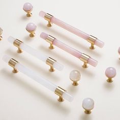 several different types of knobs and handles on a white surface with gold trimming