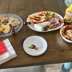 a wooden table topped with plates filled with food