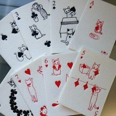 four playing cards with red ink on them are sitting next to each other in front of a mirror