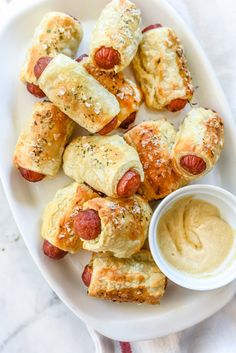 hotdogs wrapped in bread with mustard and ketchup on a white plate