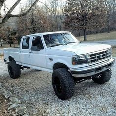 a white pick up truck parked on gravel