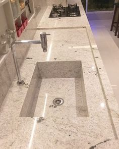 a kitchen counter top with a sink and faucet in the middle of it