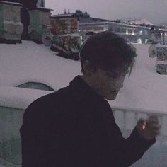 a man standing in front of snow covered buildings