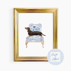 a dog sitting on top of a blue and white chair next to a gold frame