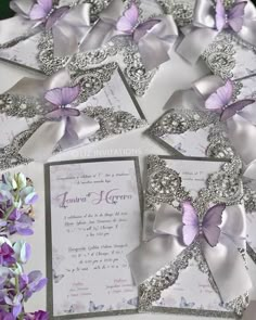 the wedding stationery is decorated with purple and silver butterflies, which are embellished with crystals