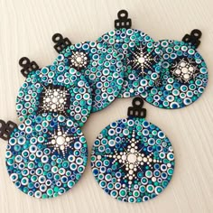 four blue and black circles with white dots on the center are hanging from black metal hooks