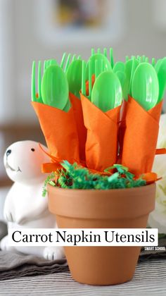 there are plastic forks and spoons in a flower pot with green decorations on it