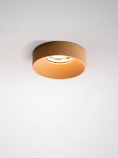 a light that is on in the ceiling with a white wall and floor behind it