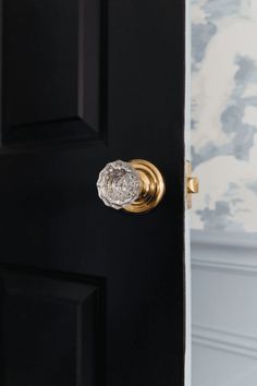 a black door with a gold handle and glass knob