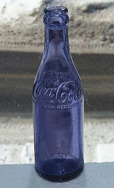 a blue glass bottle sitting on top of a window sill