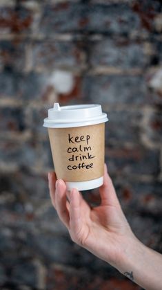 someone holding up a coffee cup with the words keep calm and drink coffee written on it