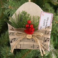 an ornament hanging from a christmas tree decorated with music notes and red berries