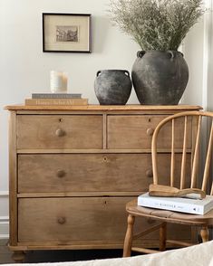 a wooden dresser with two vases on top of it